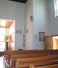 Blick in den Kirchenraum, mit Bänken, Taufkreut und Liedertafel