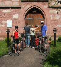 Gruppe von Radfahreren stehen vor einer Kirche